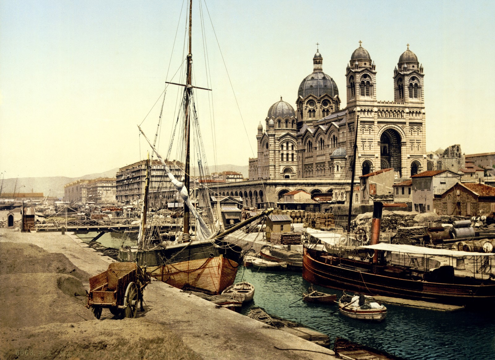 Há muitos barcos atracados no porto perto de um grande edifício. (porto, via navegável, cidade, embarcação, cartão postal)