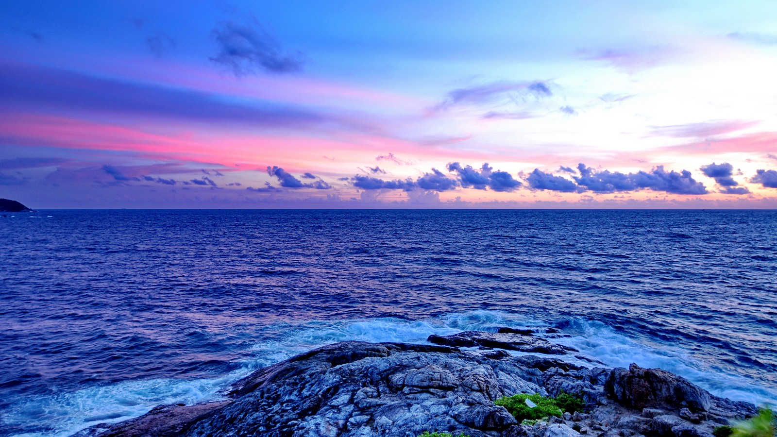 A view of a beautiful sunset over the ocean with a rock in the foreground (phuket, sea, horizon, body of water, nature)