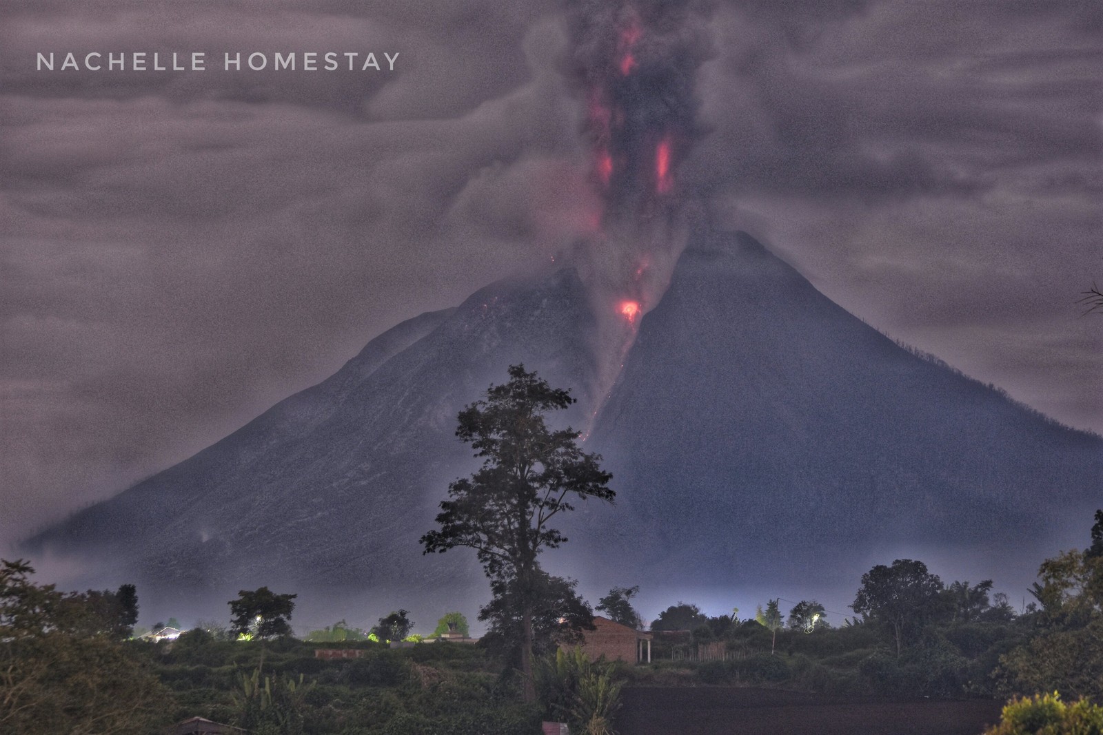 Volcan arafed avec une lueur rouge et de la fumée qui en sort (volcan, forme volcanique, arbre, atmosphère, nuage)