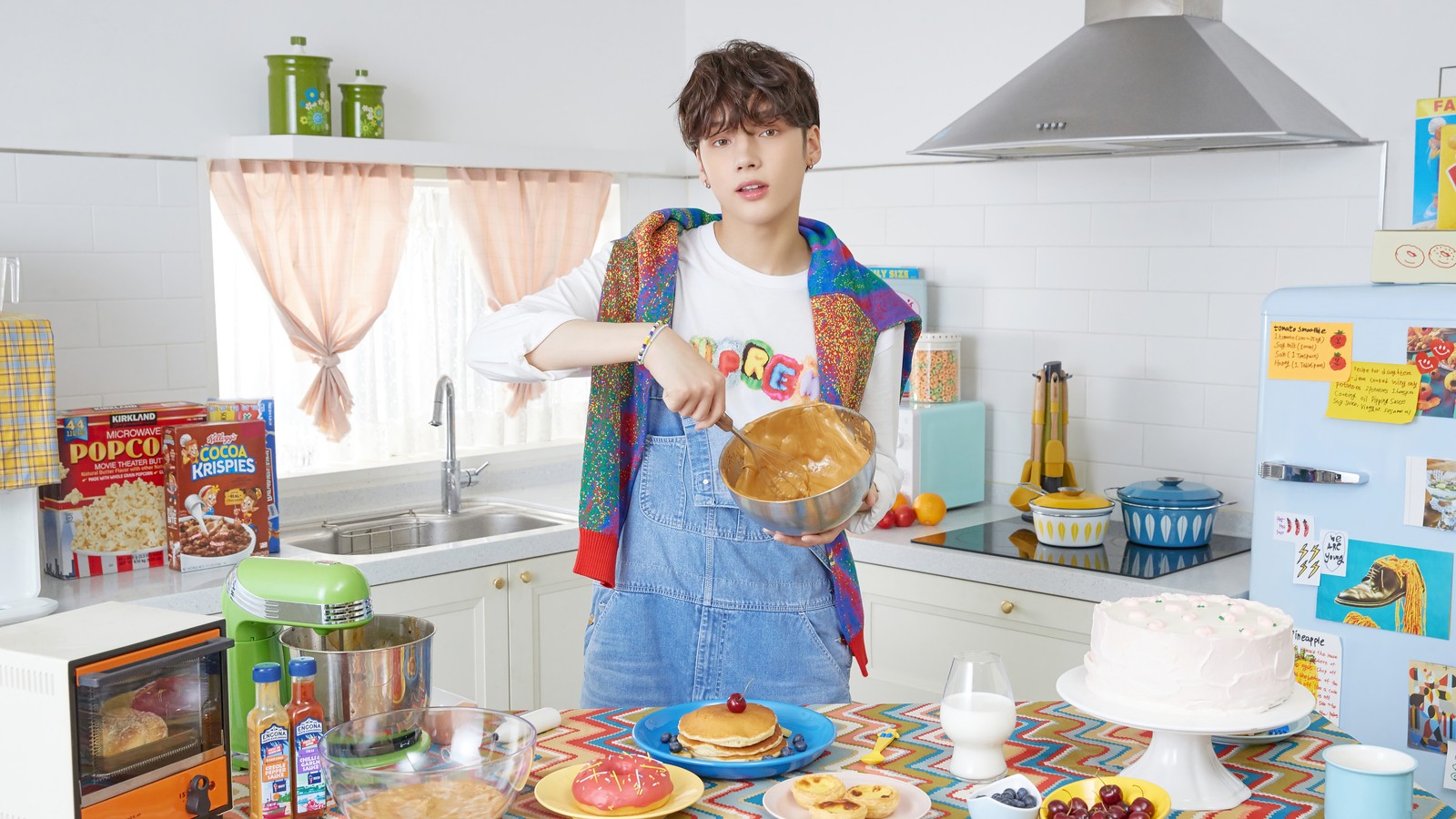 Hay una mujer de pie en una cocina con un pastel y un pastel (txt kpop, tomorrow x together, 투모로우바이투게더, kpop, k pop)