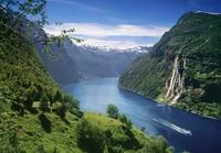 Vista de tirar o fôlego do fiorde Geiranger com cachoeiras e montanhas glaciares em uma reserva natural.