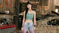 Yuna von ITZY strahlt Selbstbewusstsein in einer Vintage-Garage-Umgebung aus und zeigt ein mutiges Mode-Statement mit einem trendigen Crop-Top und zerrissenen Jeans.