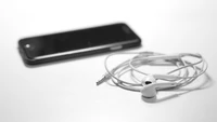 Auriculares Apple junto a un teléfono inteligente: tecnología esencial para disfrutar del audio