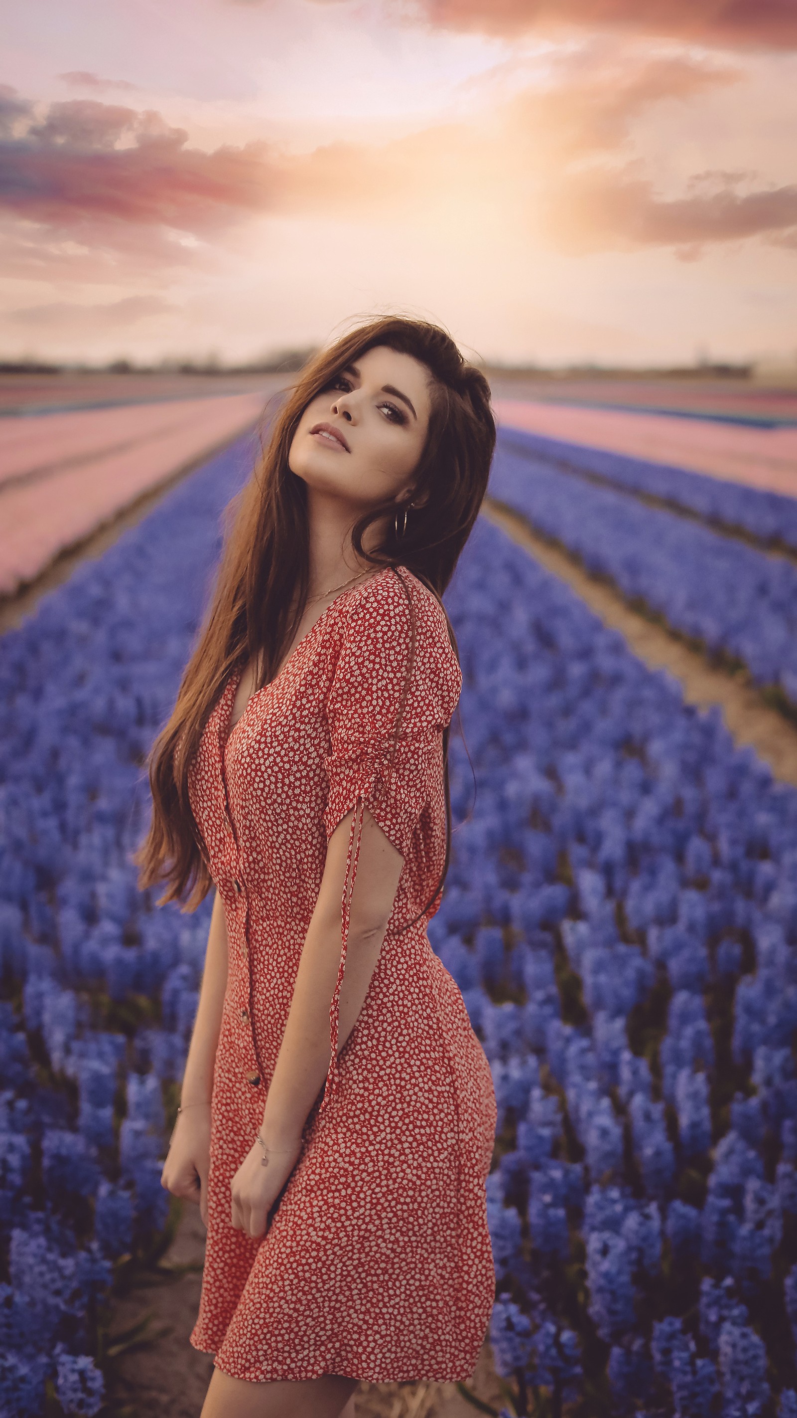 Arabische frau in einem roten kleid, die auf einem feld mit blauen blumen steht (blumenfeld, mädchen, modell, stimmung, natur)