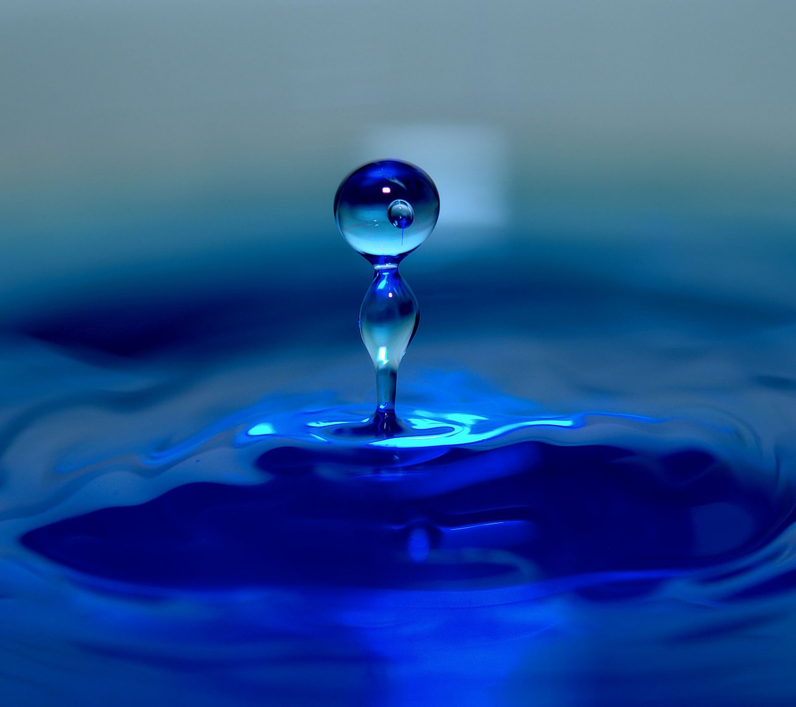 A close up of a blue water drop with a blue background (blue, drop, splash, water)