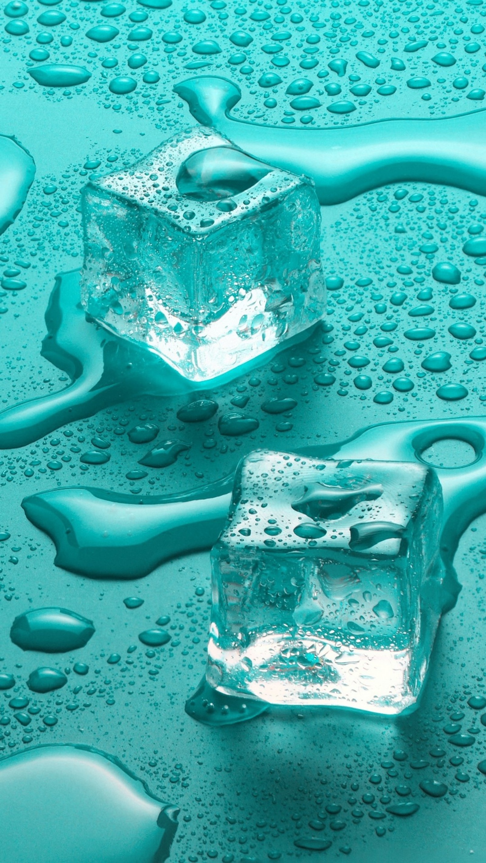 Deux glaçons posés sur une surface bleue couverte d'eau (froid, cubes, rosée, gouttes, glace)