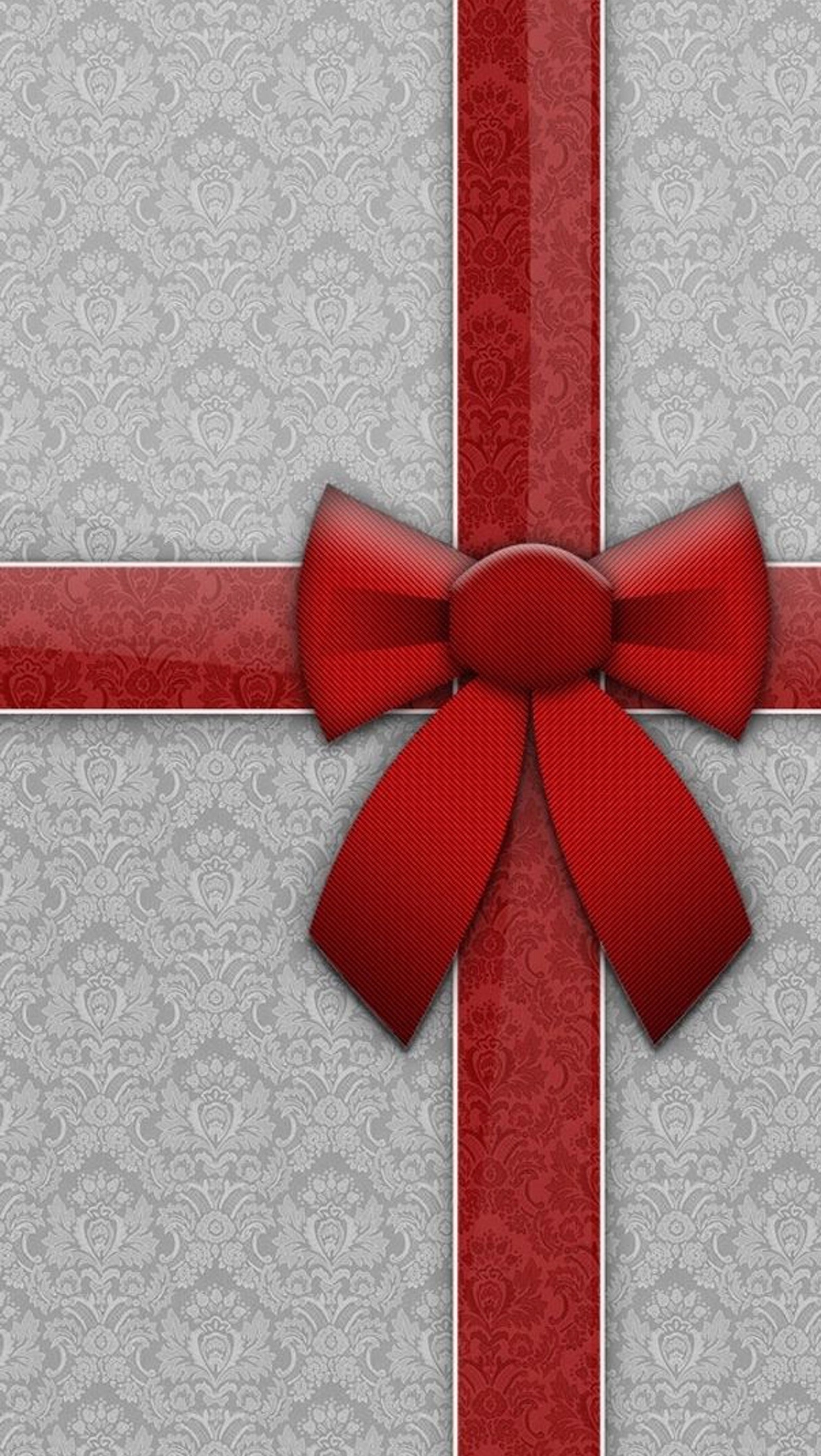 A close up of a red bow on a silver and red gift (holiday, pattern, red)