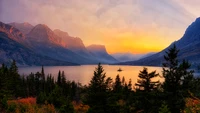 Sunrise over Saint Mary Lake, framed by rugged mountain peaks and lush wilderness.