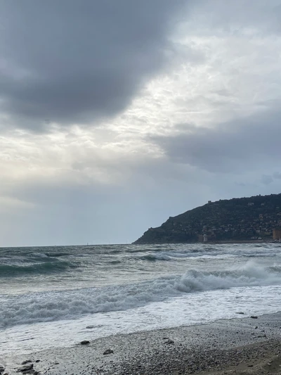 Übercast Strandlandschaft mit windigen Wellen und entferntem Horizont