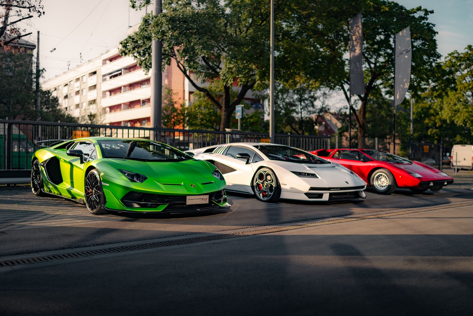 Trois voitures de sport exotiques garées dans un parking à côté d'un grand bâtiment (lamborghini aventador svj, lamborghini countach lpi 800 4, lamborghini countach lp400, voitures de sport, 5k)