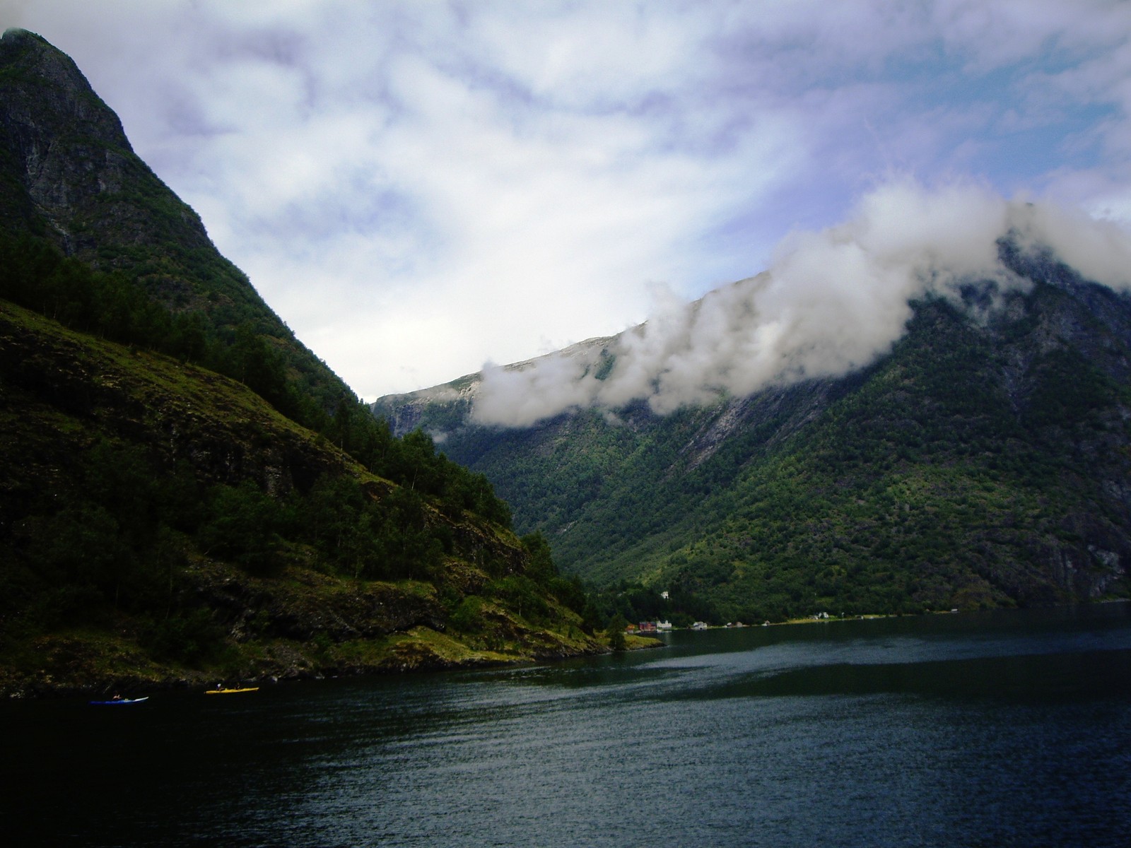 Montanhas e um corpo d'água com um barco no meio (terras altas, formas montanhosas, montanha, fiorde, natureza)