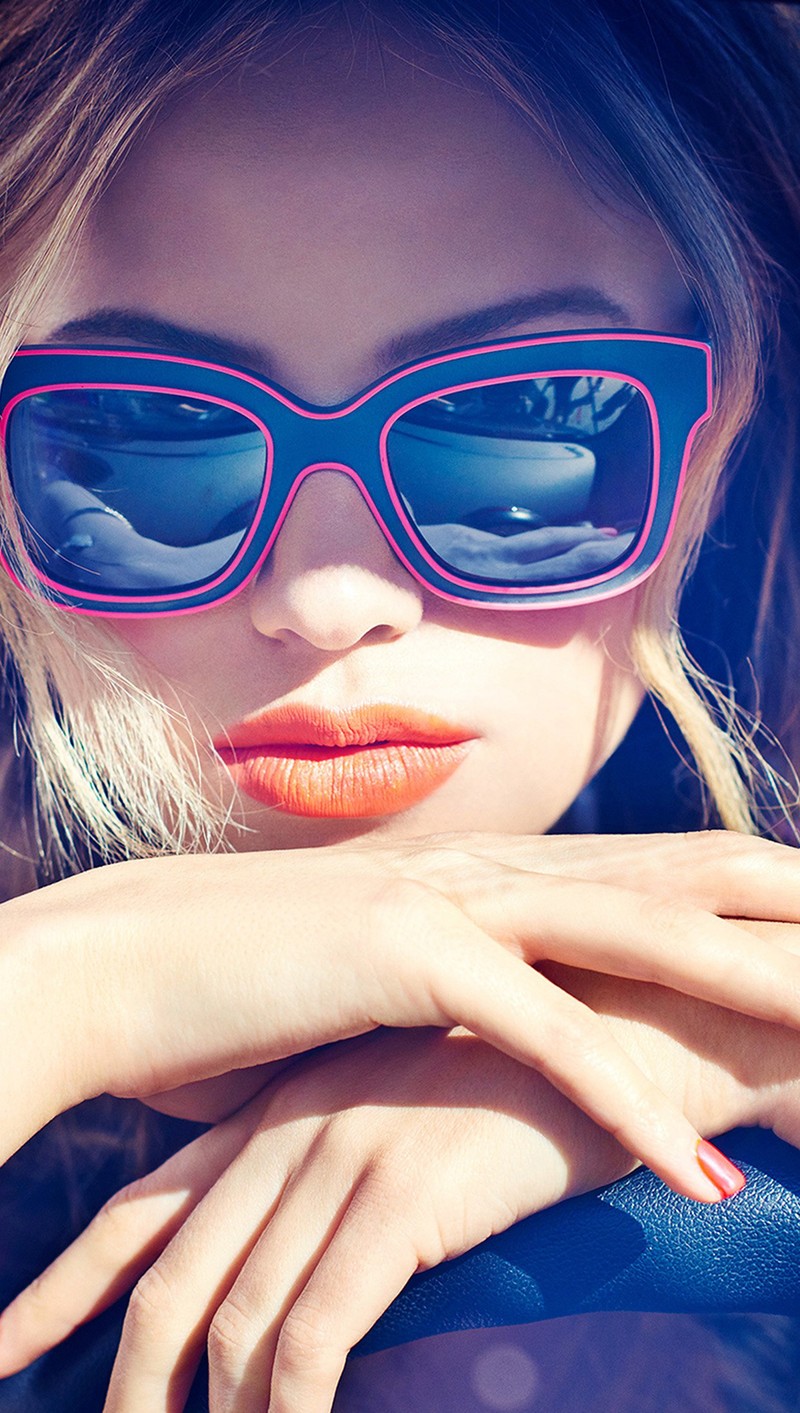 Blond woman with bright orange lips and sunglasses posing for a picture (halston, sage)