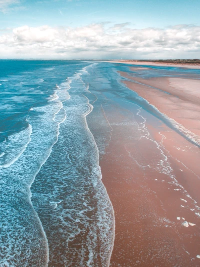 Paisagem costeira tranquila com ondas suaves e uma suave praia de areia