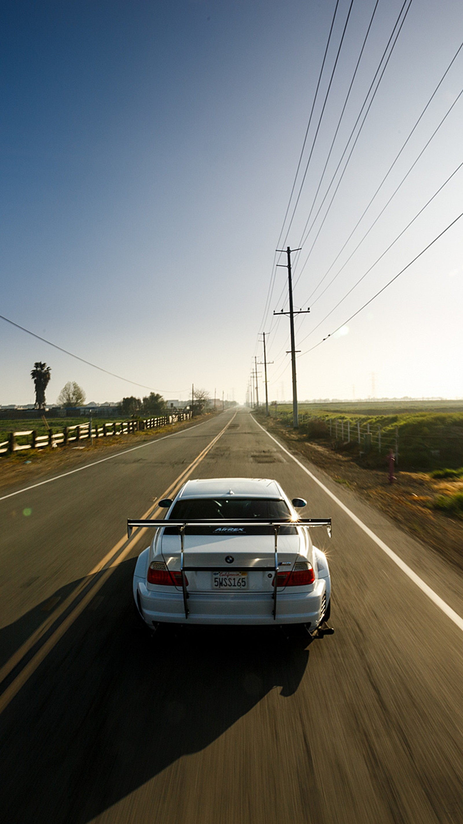 Ein weißes auto fährt an einem sonnigen tag die straße entlang (bmw, m3, geschwindigkeit)