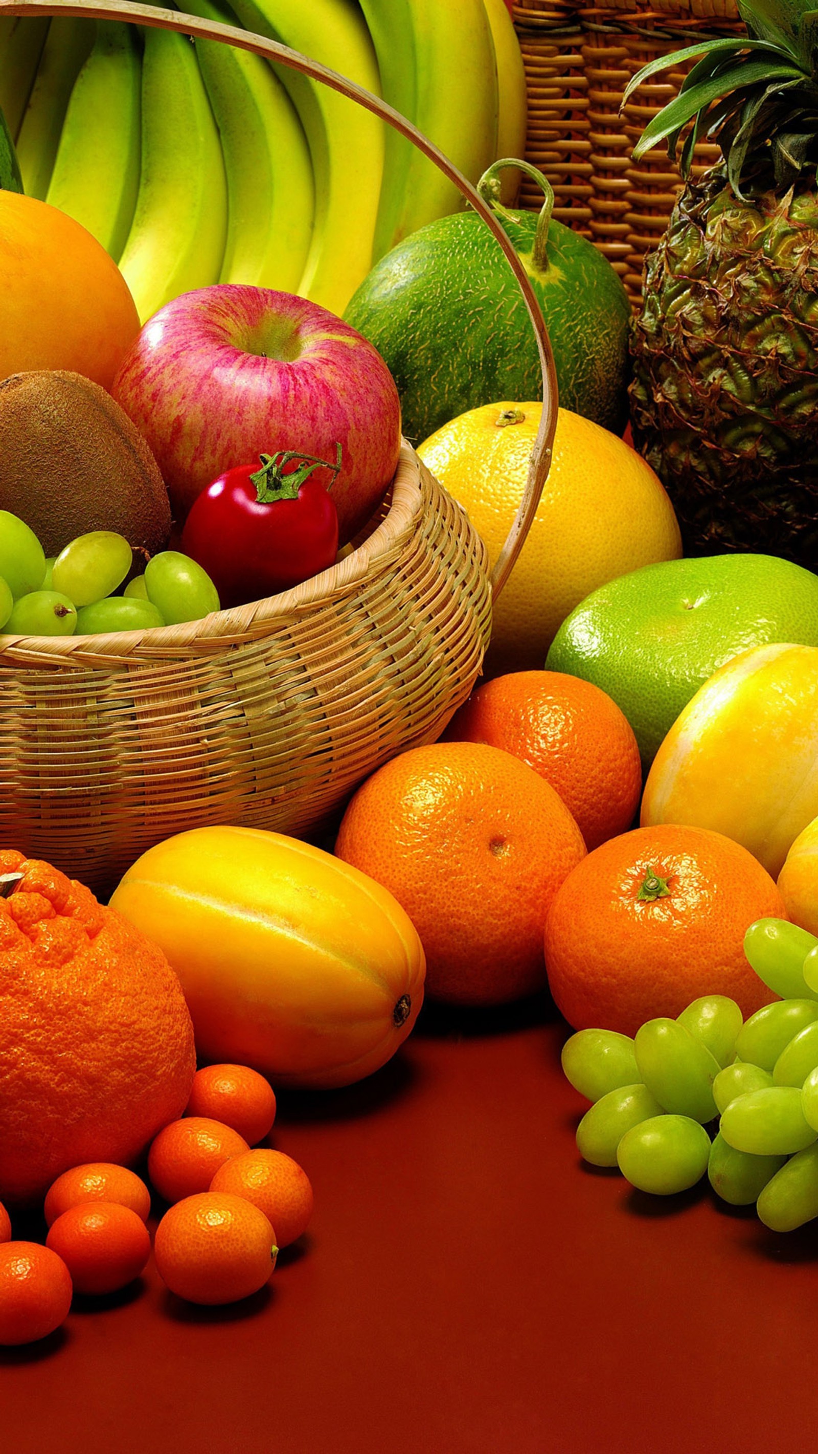 There are many different fruits and vegetables in a basket on the table (apple, banana, fruits, grapes, lemon)