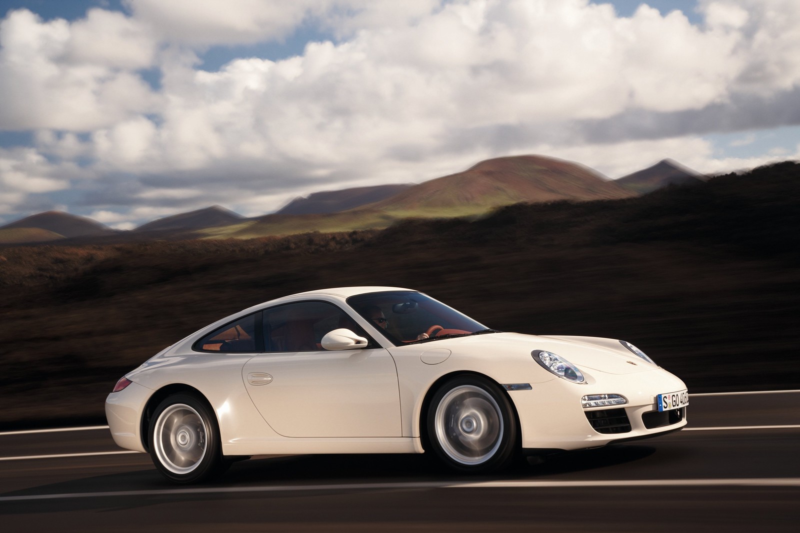 Un porsche 911 blanco aristocrático en una carretera con montañas al fondo (porsche 911, porsche, coche deportivo, porsche 911 997, porsche carrera)