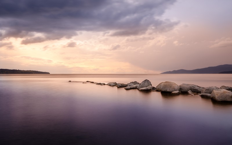 Арафед вид на озеро с камнями и облачным небом (second beach, ванкувер, морской пейзаж, камни, длительная выдержка)