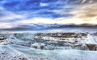 Gefrorene Majestät von Gullfoss: Winterumarmung über der arktischen Landschaft