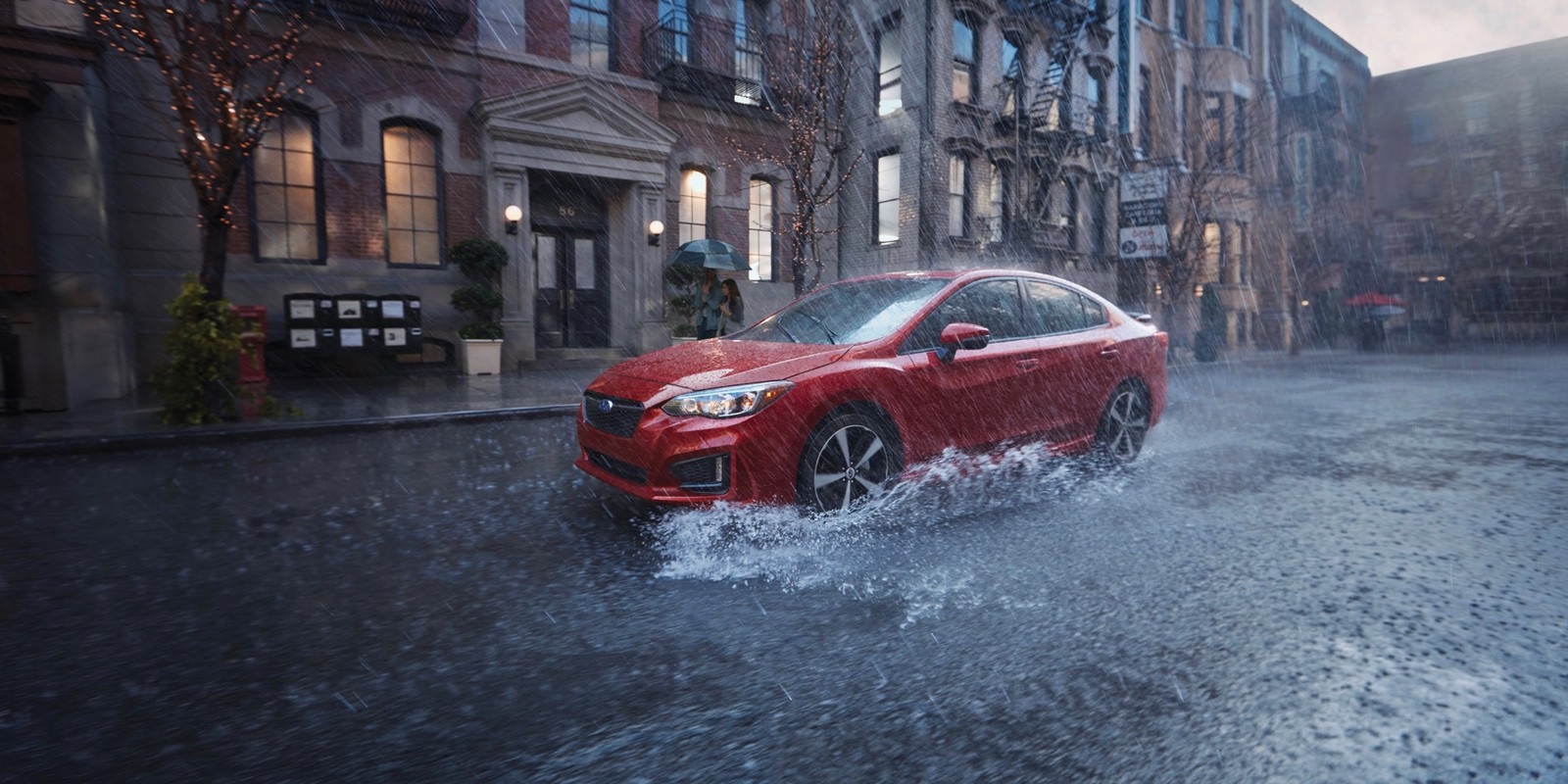 Un coche rojo conduciendo a través de un charco de agua en una ciudad (subaru, coche, coche compacto, coche urbano, coche familiar)