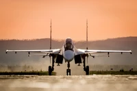 Avion de chasse Sukhoi sur la piste au coucher du soleil