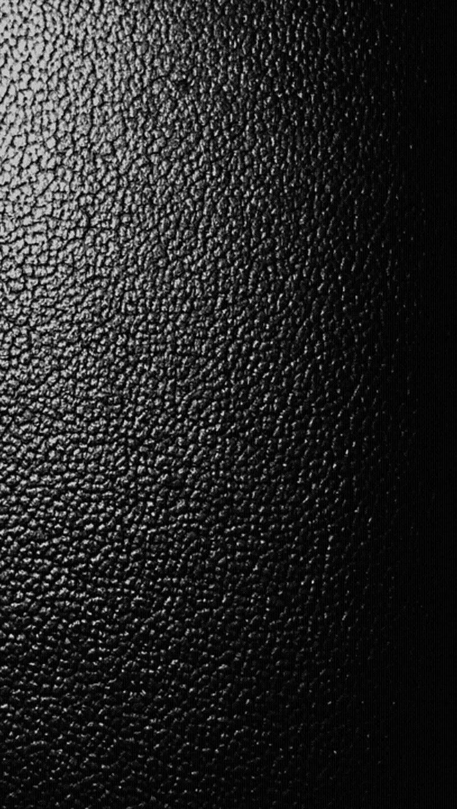 Un gros plan d'une surface en cuir noir avec quelques égratignures (abstrait, génial, noir, sympa, texture)