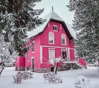 Encantadora casa rosa cercada por um país das maravilhas de inverno