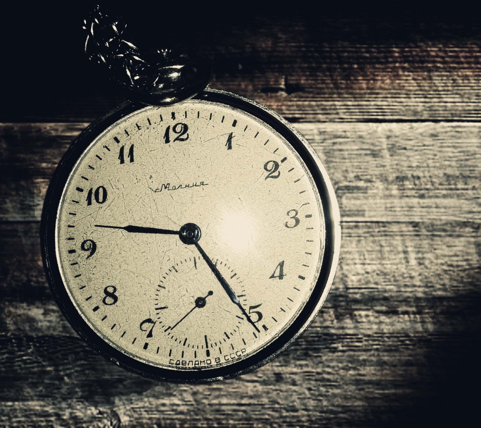 There is a clock that is on a wooden table (background, cool, old, retro, time)