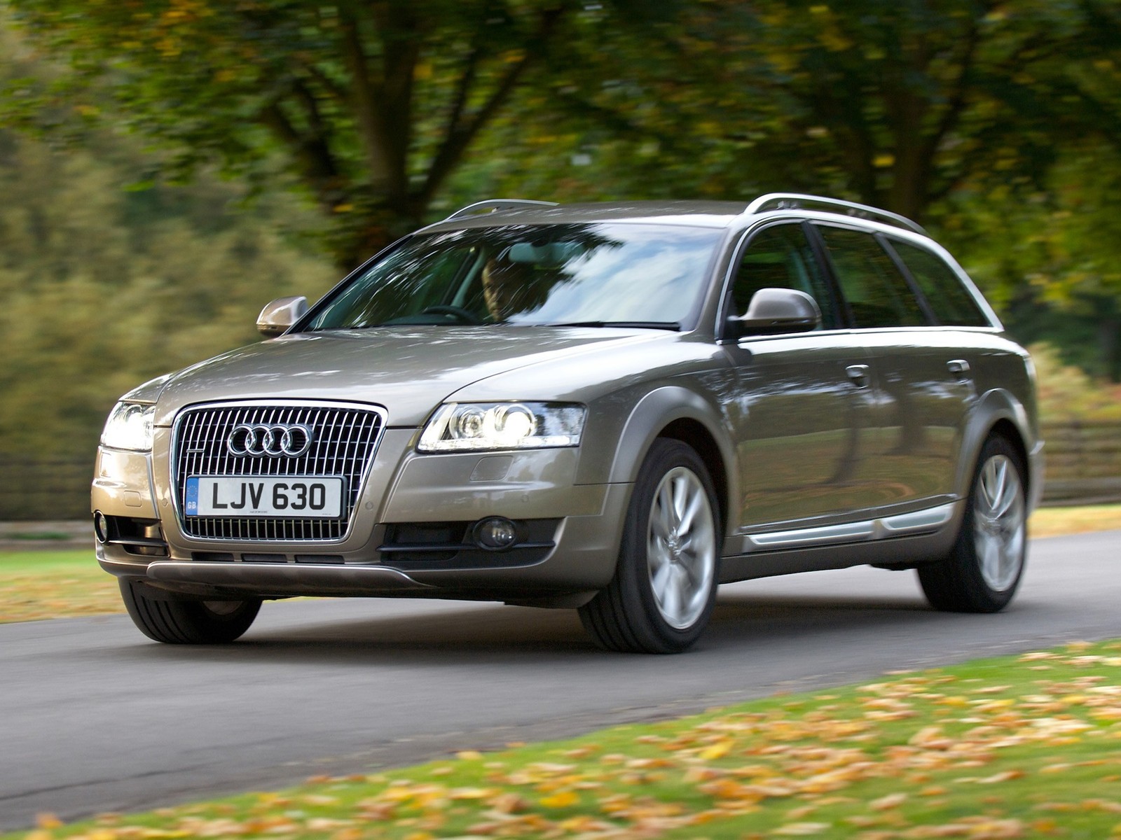 Un coche árabe plateado conduciendo por una carretera con árboles de fondo (audi allroad, audi, coche, audi a6, tecnología)