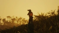 Silueta de un fotógrafo en un campo dorado al atardecer