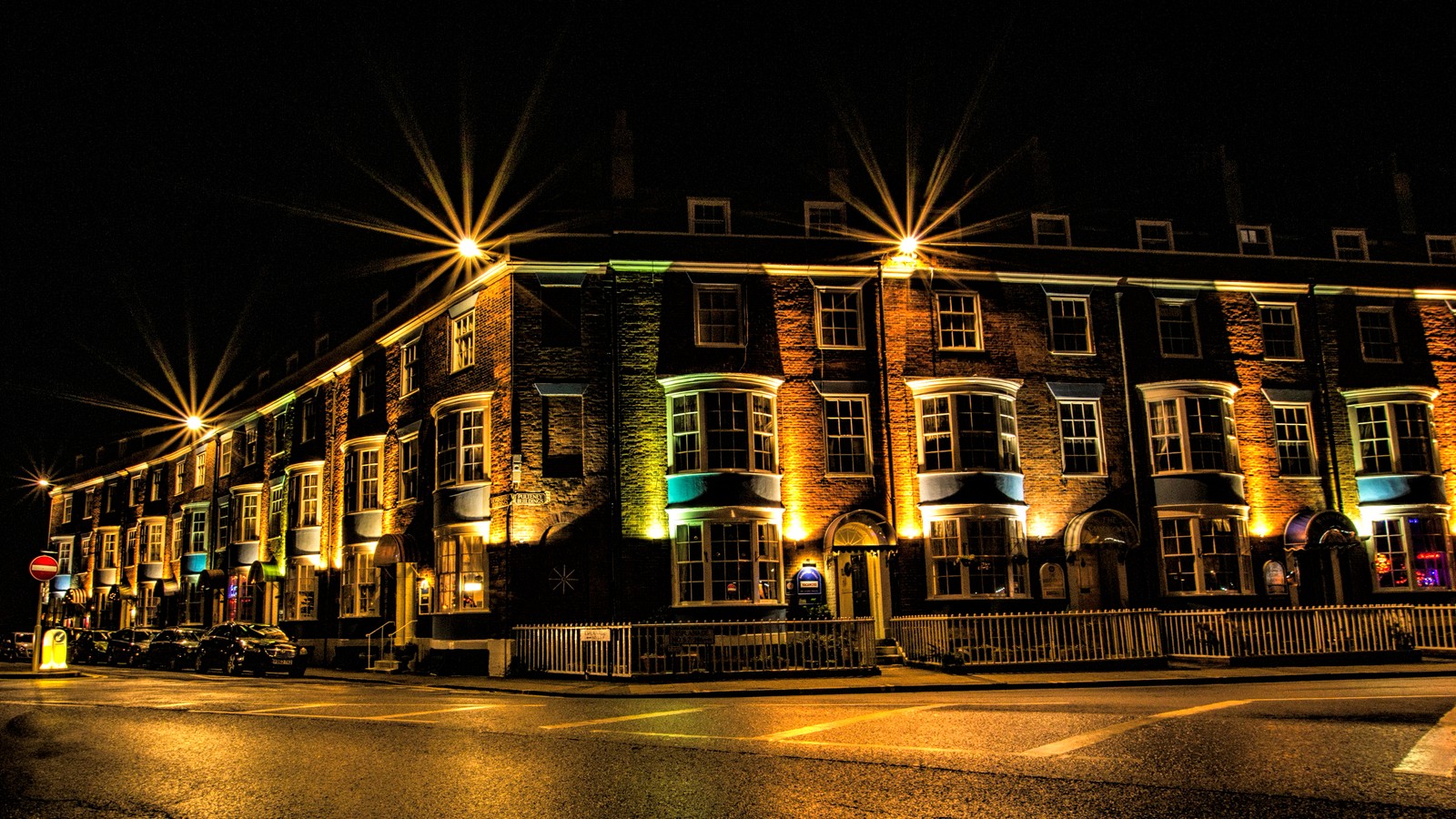 Foto noturna de uma esquina de rua com um prédio iluminado (noite, inglaterra, england, área urbana, luz)