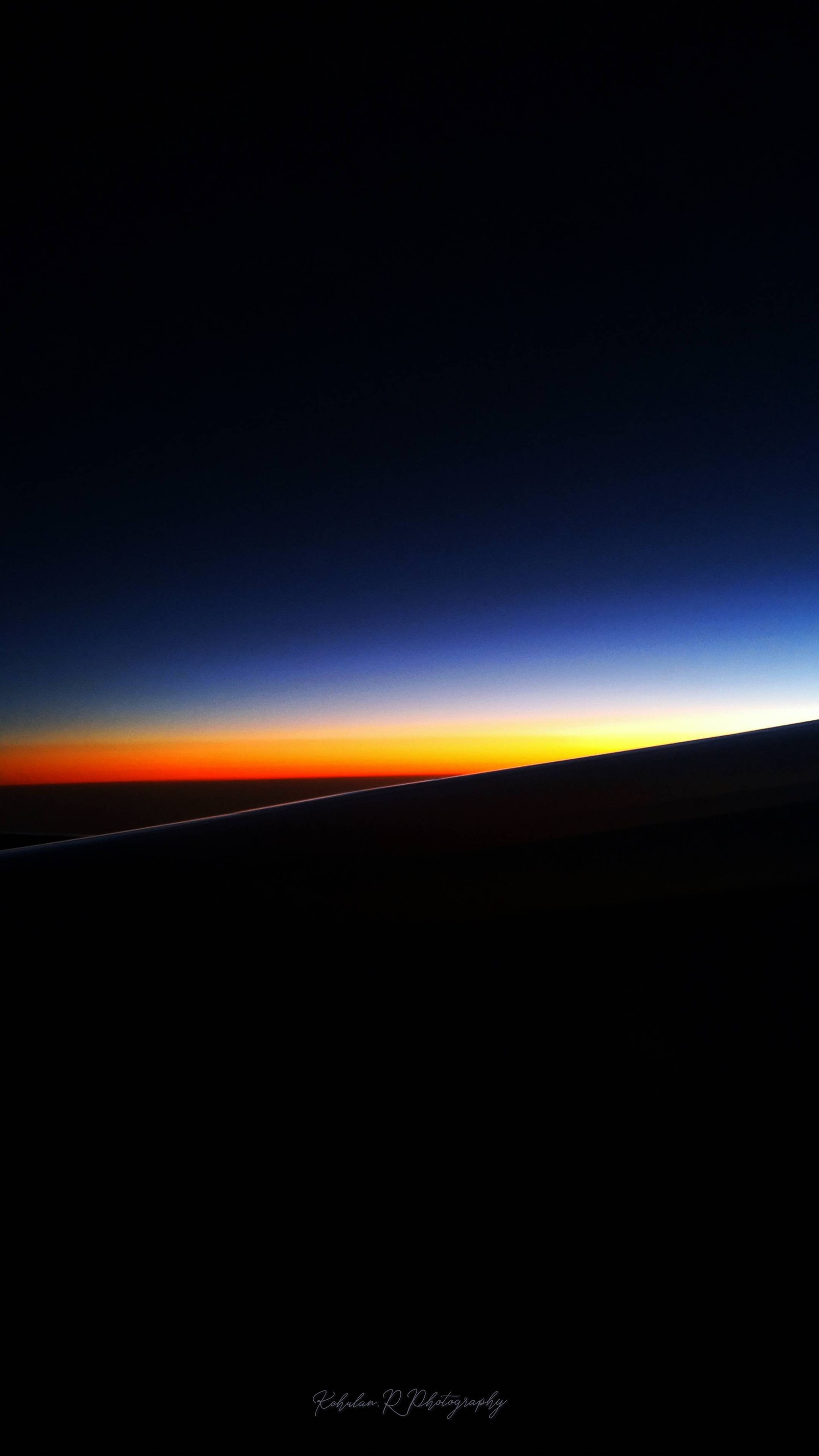 A view of the sun setting over the horizon from an airplane (atmosphere, afterglow, astronomical object, dusk, horizon)