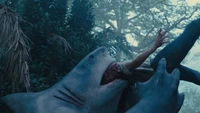 King Shark devours a victim in a jungle scene from "The Suicide Squad" (2021).