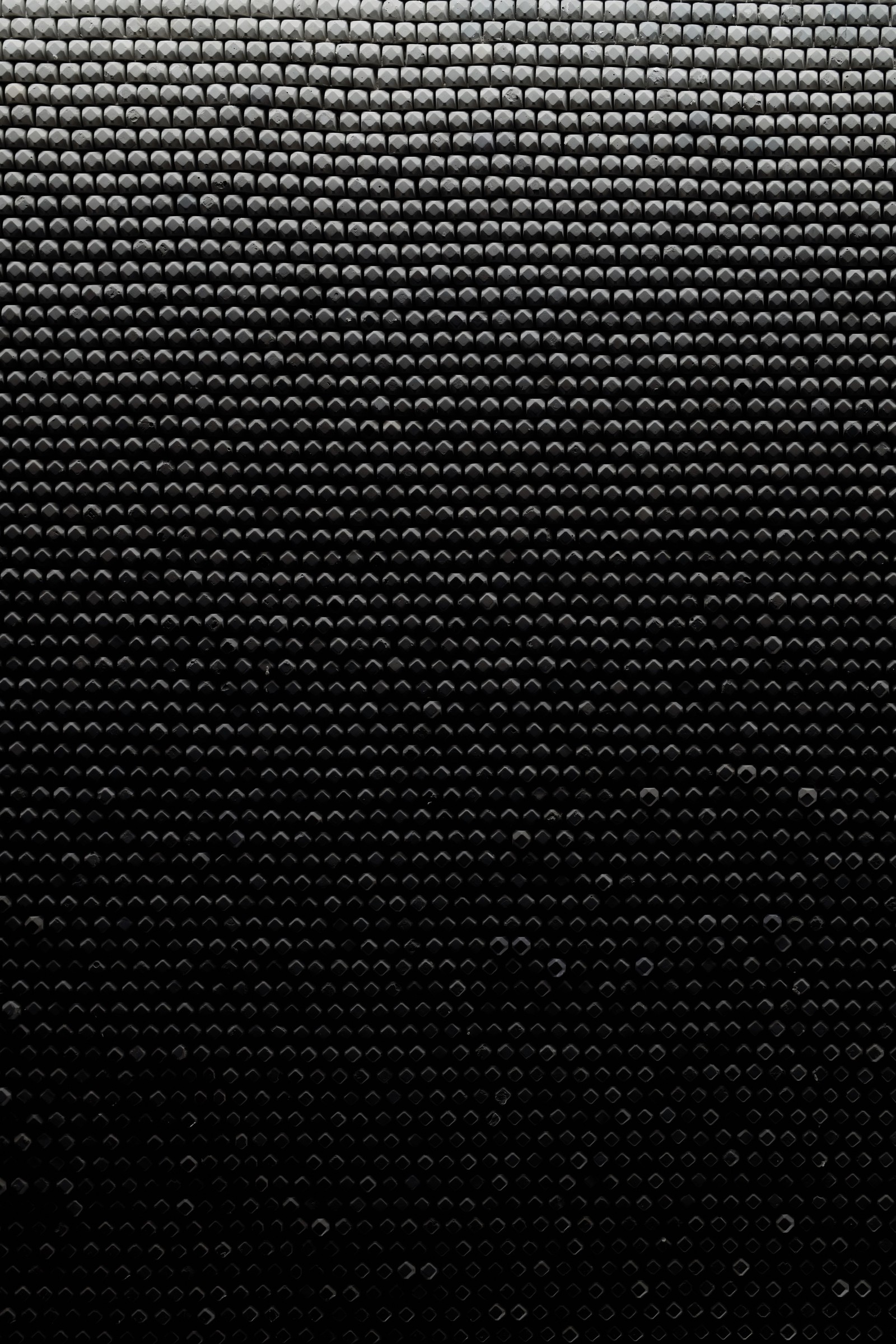 A close up of a black and white background with circles (apple, black, pattern, carbon, metal)