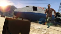 Escena llena de acción en Grand Theft Auto V: Un personaje en persecución cerca de un avión abandonado