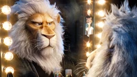 Clay Calloway, el personaje león de "Sing 2", mira pensativamente su reflejo en el espejo de un camerino, rodeado de luces brillantes.