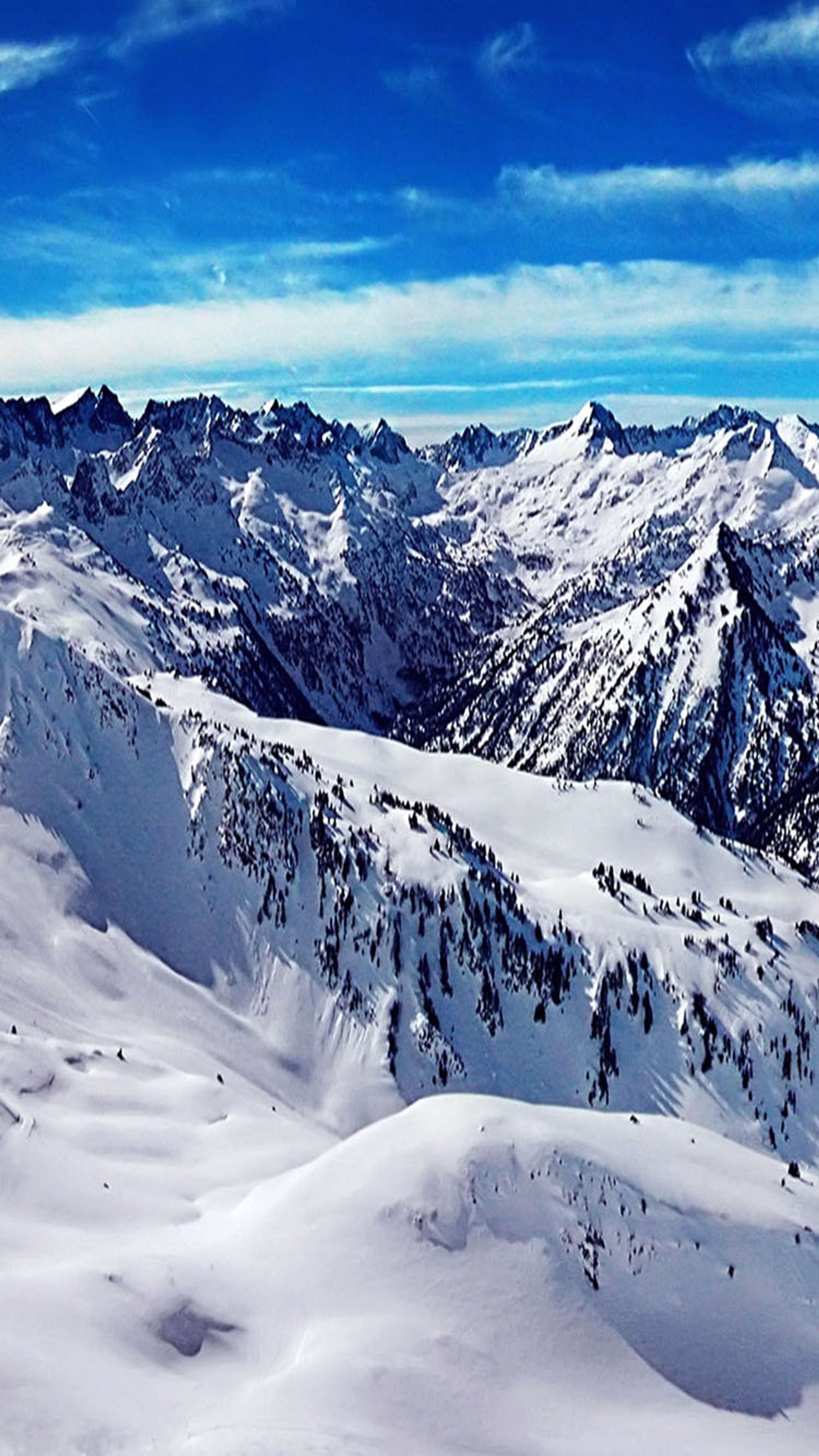 Skieurs sur une pente de montagne enneigée avec un ciel bleu (casquette, glace, neige)