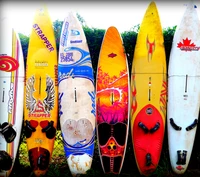 Bunte Surfboards vor einem üppigen Hintergrund im Sonnenuntergang am Meer von Maui