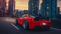 Ferrari 458 cruising through a cityscape at sunset.