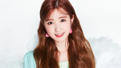 Hitomi Honda from IZONE showcasing a bright smile, featuring soft waves in her hair and playful pink earrings.