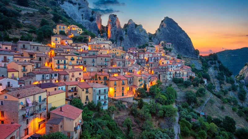 Вид на деревню в горах на фоне заката (castelmezzano, basilicata, италия, dolomiti lucane, горы)