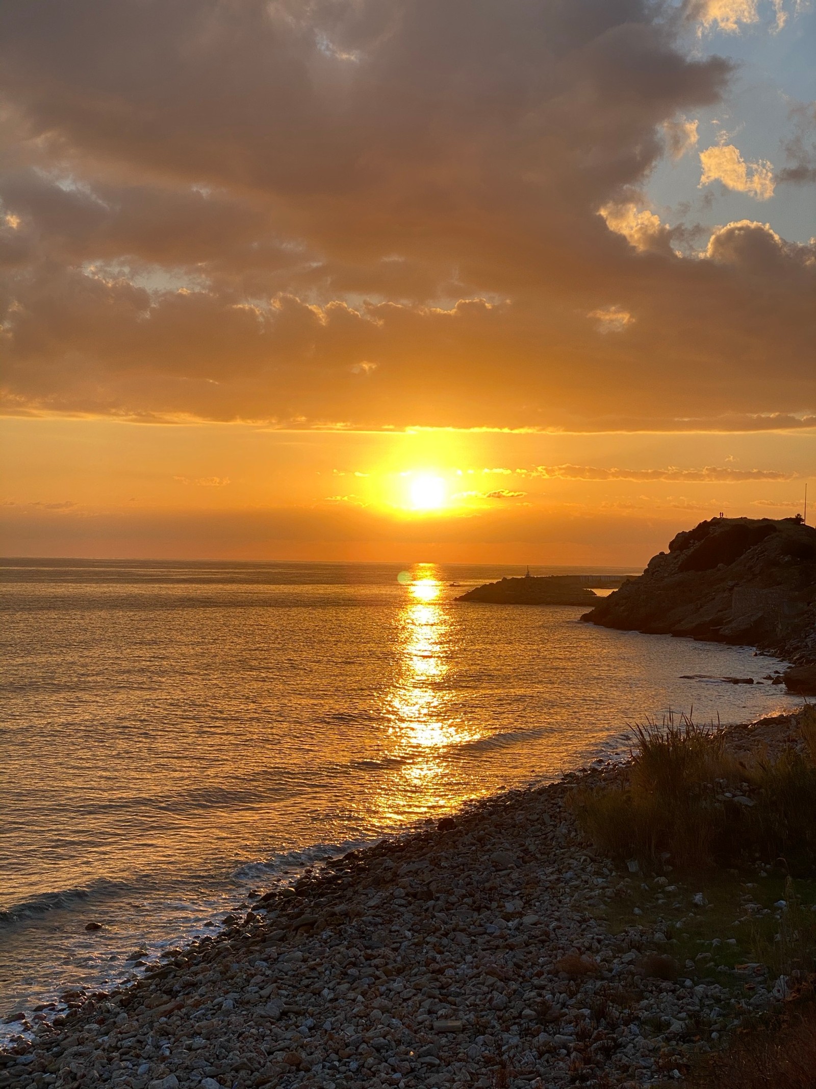 Puesta de sol sobre el océano con un bote en la distancia (horizonte, agua, nube, atmósfera, resplandor)