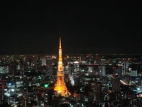 Torre de Tóquio iluminada contra o horizonte noturno da metrópole