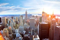 Lebendige Skyline einer pulsierenden Metropole am Tag, die ikonische Wolkenkratzer und Wahrzeichen vor einem klaren blauen Himmel zeigt.