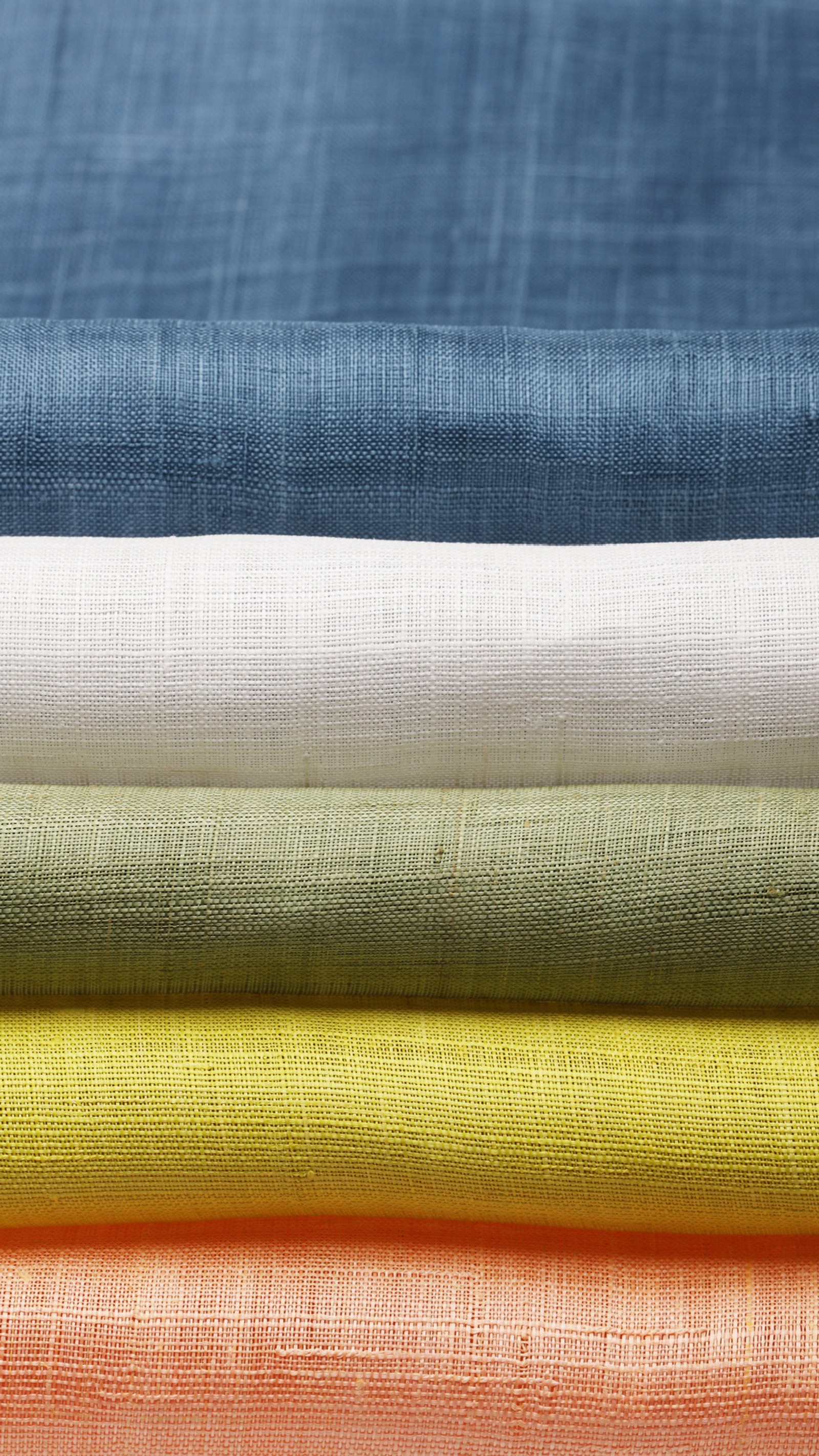 A close up of a stack of four different colored linens (elephone, elephone p9000, textile, ringtone, yellow)