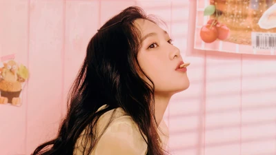 Park Soo Young von Red Velvet strahlt Freude in einer pastellfarbenen Umgebung aus und genießt einen verspielten Moment mit einem Snack.