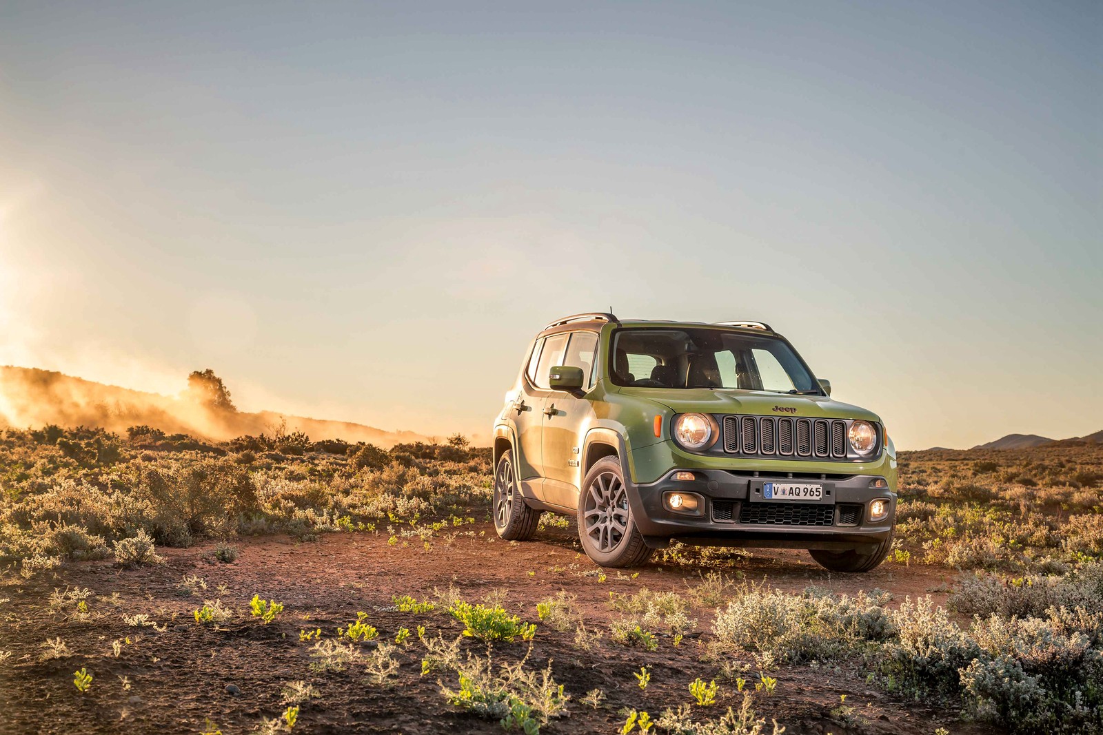 Um jipe verde dirigindo em uma estrada de terra no deserto (jeep, jeep wrangler, carro, off road, paisagem)