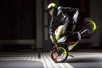 Stunt-Performer, der ein Wheelie auf einem Sportbike ausführt