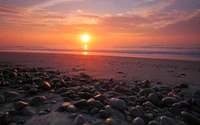 Atardecer tranquilo sobre una playa rocosa