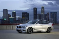 BMW Série 5 Gran Turismo: Um luxuoso Grand Tourer contra um horizonte urbano.