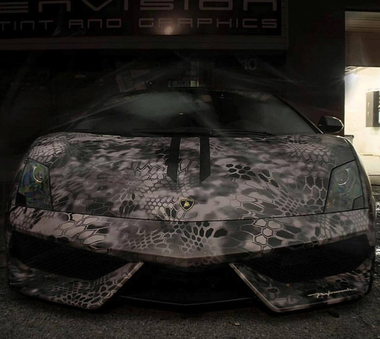 Gros plan d'une voiture avec une peinture de camouflage (voiture, lamborghini, tatouage)